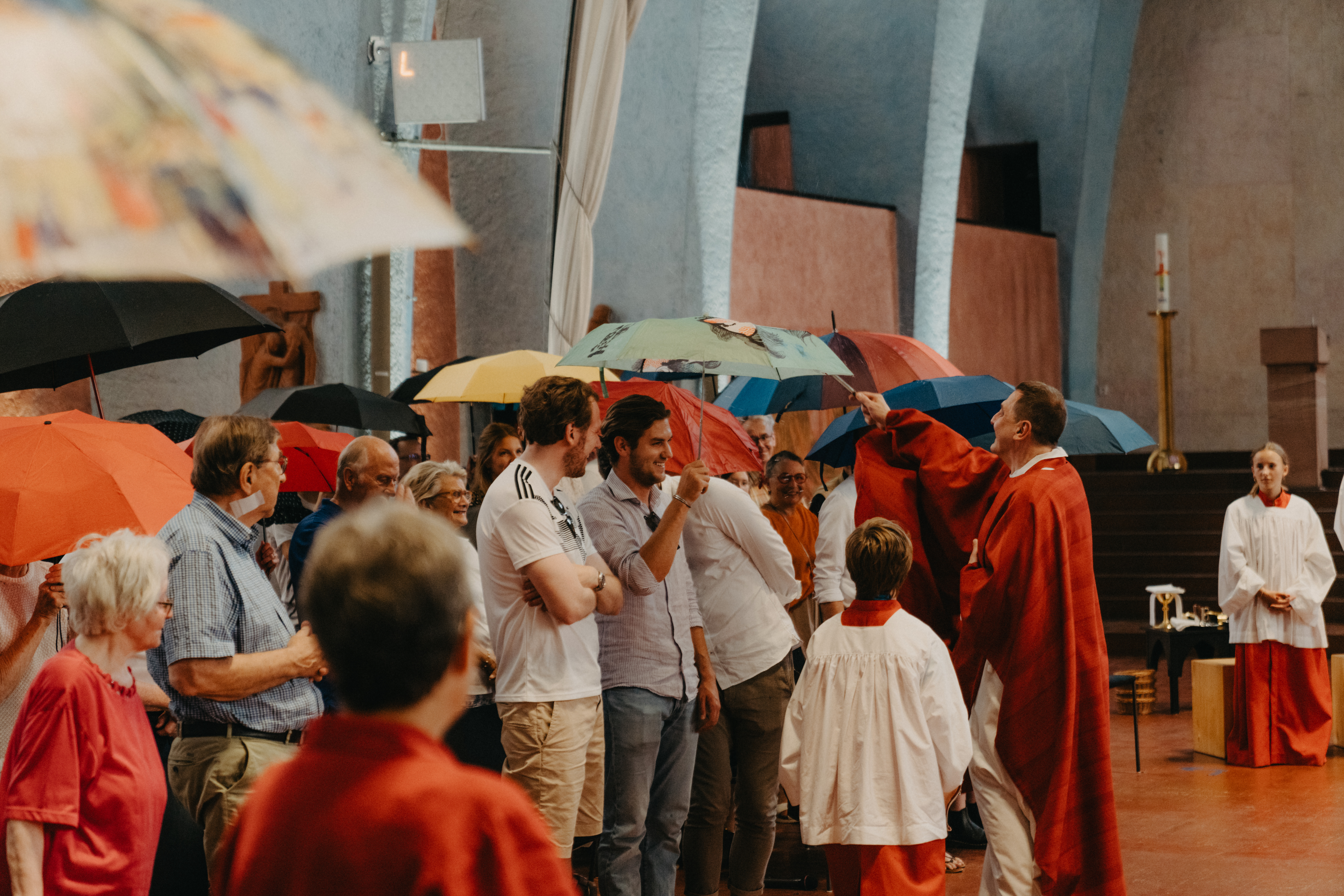 Menschen mit Regenschirmen in einer Kirche