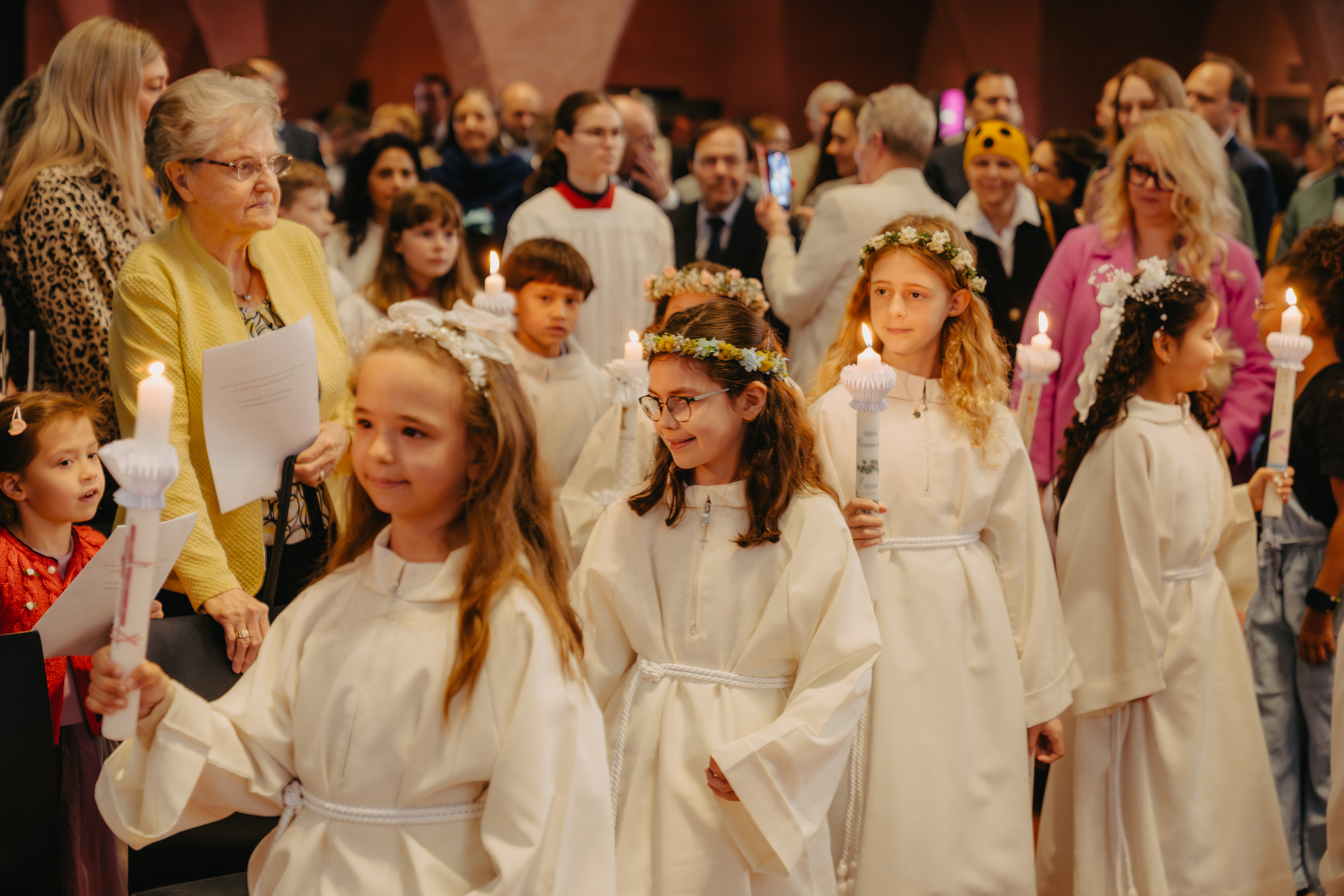 Kinder mit Kerzen bei einer Erstkommunion in Kirche